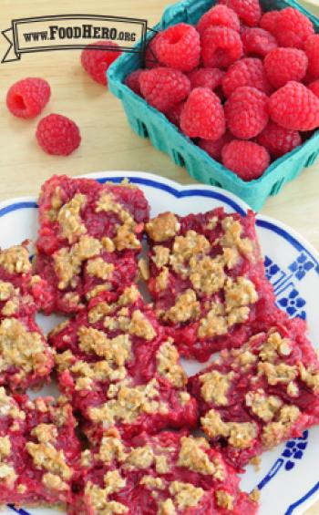 Plate of square red oatmeal and raspberry bars. 