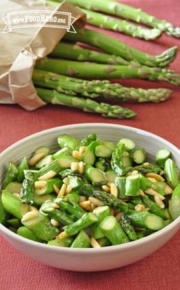 Sauteed asparagus slices with slivered almonds in a small bowl.