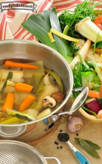 Olla llena de agua con verduras y hierbas.