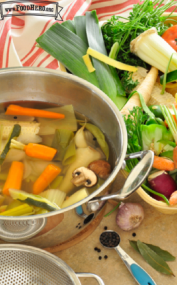 Pot full of water with vegetables and herbs.