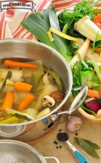 Pot full of water with vegetables and herbs. 