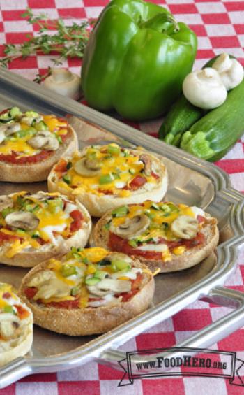 Platter of English muffins with red sauce, vegetables and melted cheese.