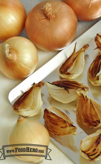 Caramelized onion quarters on a baking sheet.