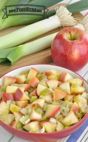 Bowl of tender leeks and red apples.
