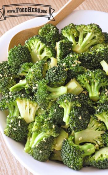 Bowl of tender broccoli sprinkled with sesame seeds.