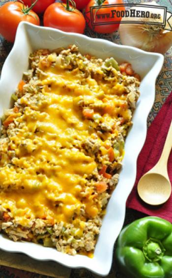 Casserole dish with rice, beef and vegetables with melted cheddar cheese. 