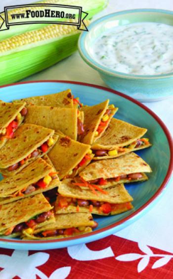 Corn tortillas folded over vegetables and cheese served with a yogurt dip.