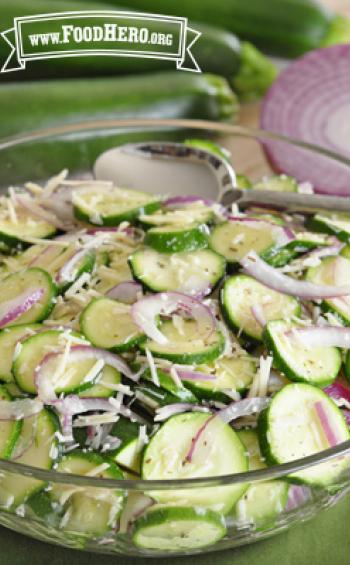 Bowl of seasoned zucchini and red onion slices.