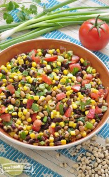 Corn, bean and vegetable mix with dressing in a large bowl.