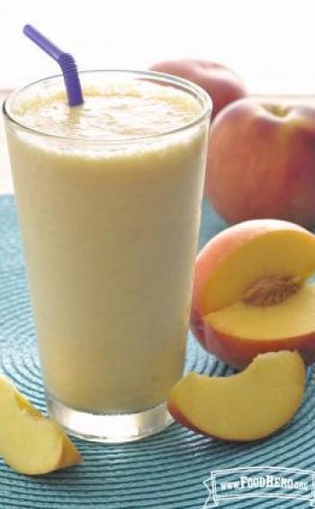 Glass filled a thick peach smoothie.