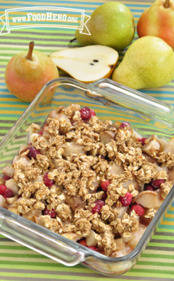 Baking dish of baked pear and cranberries with an oat topping.