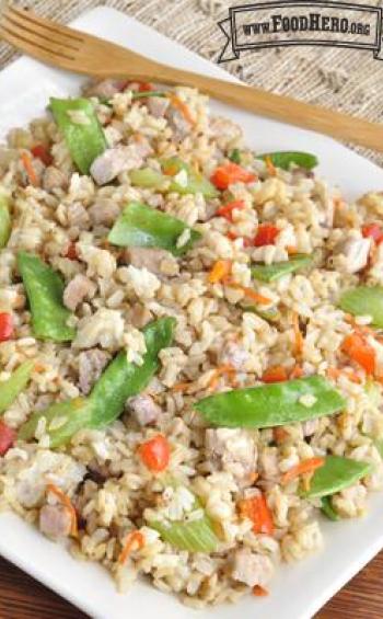 Colorful plate of sautéed rice, pork and vegetables with a soy sauce glaze.