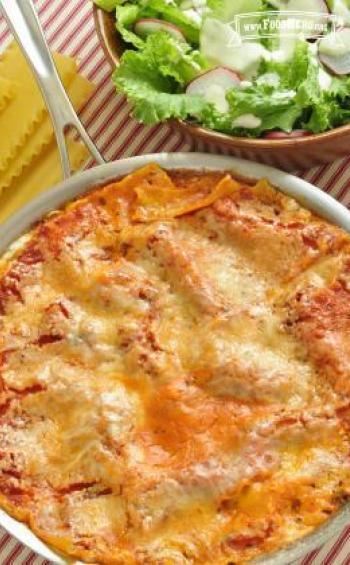 Skillet of layered flat pasta, beef, sauce and cheese.