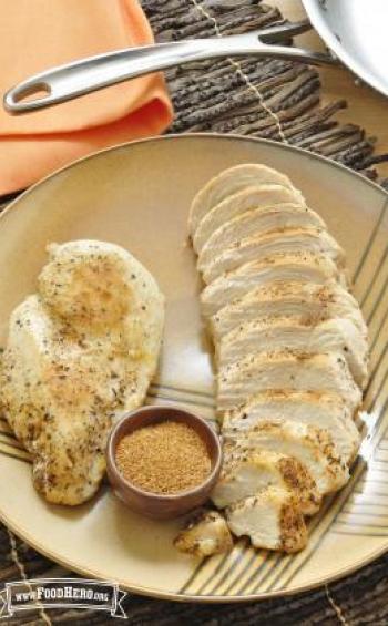 Plate with seasoned and browned chicken breasts.