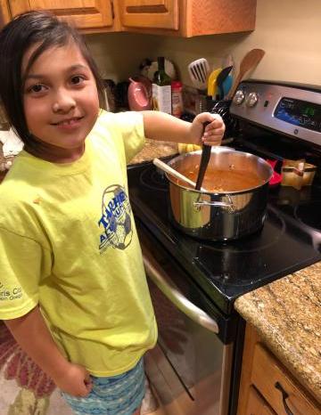 Ella cooking a Food Hero soup recipe